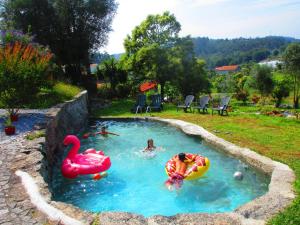 a group of people in a pool with inflatables in a yard at Quinta do Riacho in Póvoa de Lanhoso