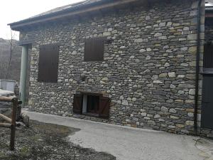 巴魯耶拉的住宿－BA12 IMMOVALL BARRUERA，一座石头建筑,设有两扇窗户和一扇门