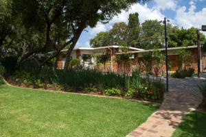 a brick house with a garden in front of it at Classique Grace Boutique Hotel in Johannesburg