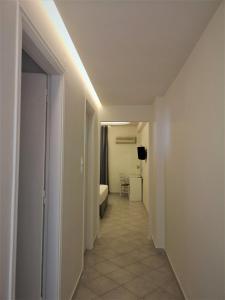 a hallway leading to a room with a bed and a room with a hallwayngth at Neorio Studios in Poros