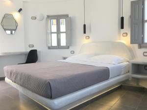 Bett in einem weißen Zimmer mit Fenster in der Unterkunft Argonaftes in Firostefani