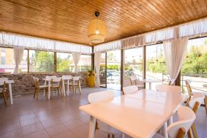 a restaurant with tables and chairs and windows at Marieta-Giannis in Faliraki