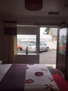 a bedroom with a bed and a view of a parking lot at The Thistle Inn in Stranraer