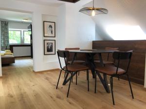 een eetkamer met een zwarte tafel en stoelen bij Style Apartments by Mieze Schindler in St. Wolfgang