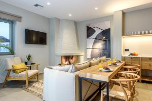 a living room with a table and a fireplace at Caldera Theros Villas in Hersonissos