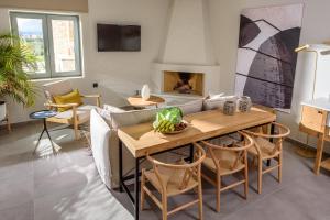 a living room with a couch and a table and a fireplace at Caldera Theros Villas in Hersonissos