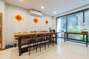 uma cozinha com uma mesa e bancos contra uma parede de tijolos em Tofu's House - A place called Home em Hanói