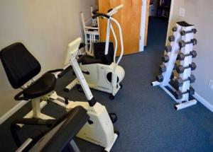 a gym with several tread machines in a room at A Place at the Beach by Capital Vacations in Myrtle Beach
