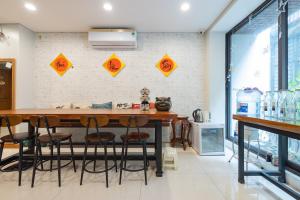 Tofu's House - A place called Home في هانوي: مطبخ مع طاولة وكراسي وجدار به لافتات