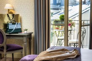 Habitación de hotel con balcón con mesa y sillas en Arioso en París