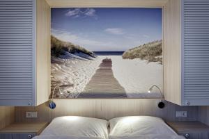 a bedroom with a picture of a boardwalk on the beach at Duus Hotel garni in Wyk auf Föhr