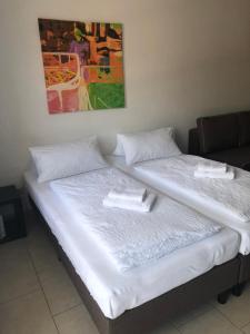 2 camas en una habitación con sábanas blancas y toallas en FeWo Konstanz Zentrum , 900 m zum See en Konstanz