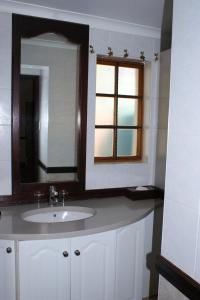 a bathroom with a sink and a mirror and a window at Kievits Kroon Gauteng Wine Estate in Pretoria