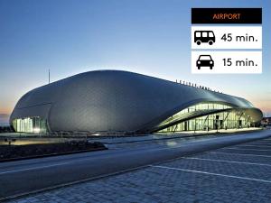 a large building with a curved roof next to a road at 6th Sense Apartments in Brno