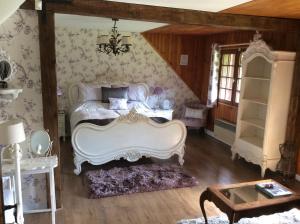 a bedroom with a white bed and a table at Spruce Lake in Sauviat-sur-Vige