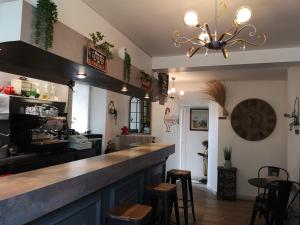 a kitchen with a counter and stools in a room at Le Saint Mary in Mauriac