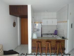 a kitchen with a counter with stools in it at Flat Jardim de Alah in Salvador