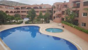 a large swimming pool in front of a building at Beau Duplex à Imi ouaddar in Agadir nʼ Aït Sa