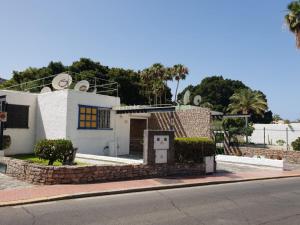 Ein weißes Haus an der Seite einer Straße in der Unterkunft Bungalows Bahamas beside the park and 300m to the beach in Puerto Rico de Gran Canaria