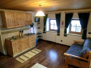 a living room with a couch and a kitchen at Virtus Et Otium - Feldererhof in Vipiteno