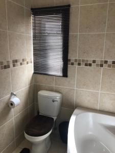 a bathroom with a toilet and a sink and a window at Sweet Home Alibama in Nelspruit