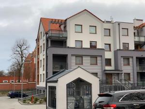 un bâtiment avec une voiture garée devant lui dans l'établissement Apartament Zacisze Rose Gold, à Malbork