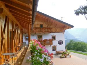 a building with a balcony with flowers on it at Virtus Et Otium - Feldererhof in Vipiteno