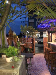 a restaurant with plants and a bar with blue lights at Golf House in Phuket