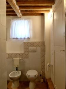 a small bathroom with a toilet and a window at MONOLOCALE CASENUOVE con GIARDINO in Castiglioncello