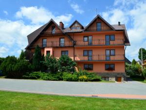 a large house with a gambrel roof at Pokoje i Apartament u Lucyny in Czarna Góra