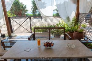 a table with a bowl of fruit and a glass of orange juice at Premier Sea Apartment in Paleo Tsifliki