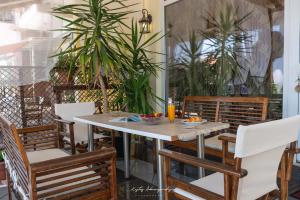 einen Tisch und Stühle auf einer Terrasse mit Pflanzen in der Unterkunft Premier Sea Apartment in Palaió Tsiflíki