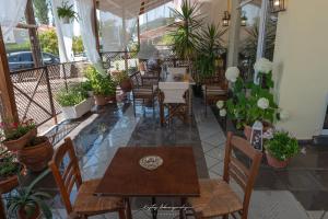a restaurant with tables and chairs and potted plants at Premier Sea Apartment in Paleo Tsifliki