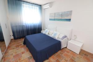 ピアノ・ディ・ソレントにあるBaia della Serenitàのベッドルーム(青いベッド1台、窓付)