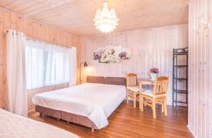 een slaapkamer met een bed en een tafel en stoelen bij Pokoje Gościnne Lidka in Dziwnów