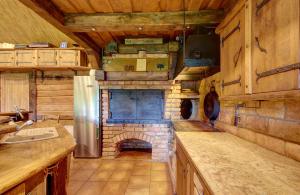 a large kitchen with a stone fireplace in a cabin at Prie Klykio in Utena +126 photos
