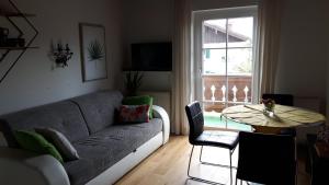 salon z kanapą, stołem i oknem w obiekcie Haus Gertrude Hörack w mieście St. Wolfgang