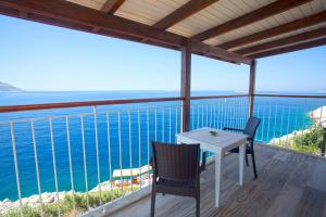 a table and chairs on a balcony overlooking the ocean at Sunset Villa Hotel in Kaş