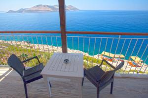 a table and chairs on a balcony with a view of the ocean at Sunset Villa Hotel in Kaş