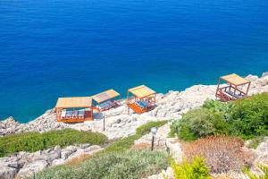 un groupe de maisons au sommet d'une colline près de l'eau dans l'établissement Sunset Villa Hotel, à Kaş