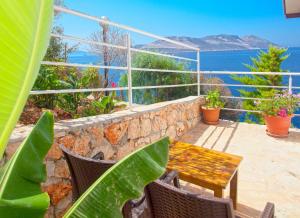 a patio with a table and chairs and the ocean at Sunset Villa Hotel in Kaş