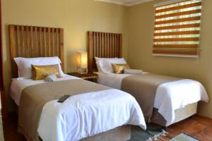 1 Schlafzimmer mit 2 Betten und einem Fenster in der Unterkunft Leago Guesthouse in Bloemfontein