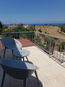 a balcony with a table and a chair and the ocean at Panoramic sea view apartment in Polis-Latchi in Polis Chrysochous