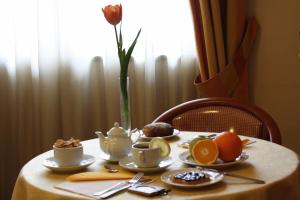 a table with cups and plates of food on it at Hotel Europa in Naples