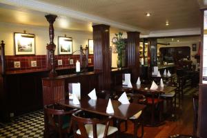 una sala da pranzo con tavoli e sedie in legno di O'Shea's Hotel a Tramore