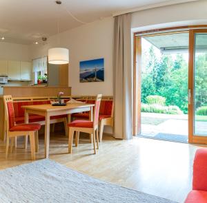 a kitchen and dining room with a table and chairs at Gartenlodge Auszeit in Nötsch