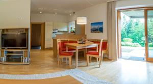 a kitchen and living room with a table and chairs at Gartenlodge Auszeit in Nötsch