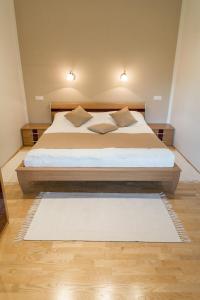 a bedroom with a large bed and a white rug at Gartenlodge Auszeit in Nötsch