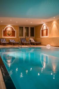 a large swimming pool in a hotel with lounge chairs at Residence Bellevue in Boppard