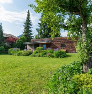 a brick house with a yard in front of it at Gartenlodge Auszeit in Nötsch